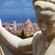 A marble statue of a young woman with the Duomo in the background